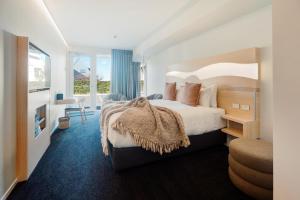 陶朗加CitySide Hotel Tauranga的酒店客房设有一张大床和一个阳台。