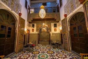 非斯Riad Qamar Fez的华丽的客房铺有瓷砖地板,设有门