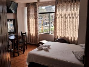 利马LAS ARTES INN的酒店客房设有两张床和窗户。