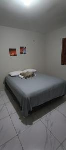 乌巴雅拉Chácara Mount Sinai的一张位于白色房间的床,墙上有两张照片