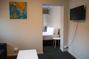 LindisfarneBeltana Hotel的客房设有一张床和一台平面电视。