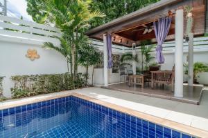 拉威海滩Jasmine Pool Villa in Nai Harn的一座带游泳池和庭院的房子