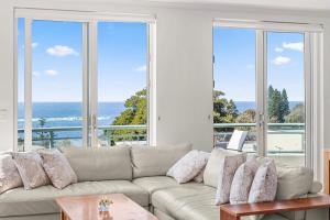 悉尼AeA库吉美景公寓酒店的带沙发的客厅,享有海景