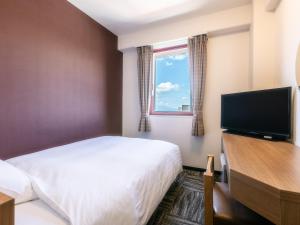 Sukagawa须贺川永国际酒店的配有一张床和一台平面电视的酒店客房
