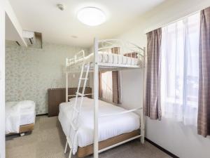 Sukagawa须贺川永国际酒店的一间卧室设有两张双层床和一扇窗户。