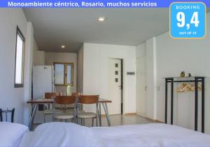 罗萨里奥Monoambiente Céntrico, Nuevo, Cochera y Muchos mas servicios的配有一张床和一张桌子及椅子的房间
