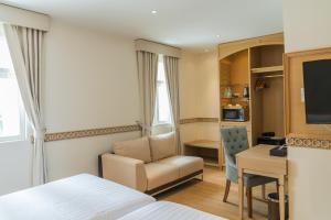 曼谷拉普提萨利尔素坤逸通罗1的酒店客房配有一张床、一把椅子和一张书桌