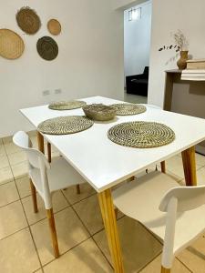 奇莱西托Departamento Cristo del Portezuelo I的一张白色的桌子,上面有白色的椅子和盘子