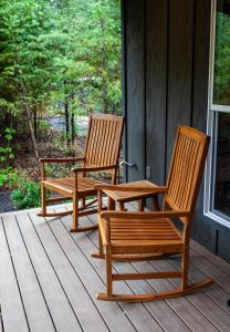 CarsonBackwoods Cabins的两把木椅坐在房子的门廊上