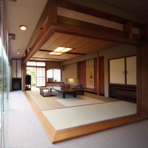 函馆一乃松日式旅馆的大房间,配有桌子和长凳
