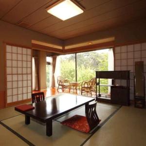 函馆一乃松日式旅馆的客厅配有桌椅和窗户。