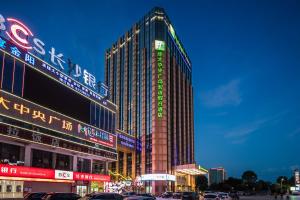 浏阳浏阳博大中央广场智选假日酒店的城市中一座有 ⁇ 虹灯标志的高楼