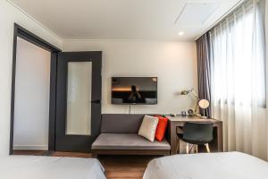 西归浦市Hotel The Grang Jungmun的酒店客房配有一张床、一张桌子和一把椅子。
