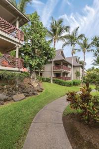 科纳Club Wyndham Kona Hawaiian Resort的棕榈树的房子,前面有人行道