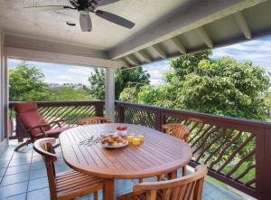 科纳Club Wyndham Kona Hawaiian Resort的阳台配有一张木桌和椅子,