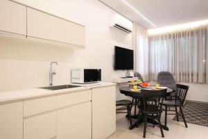 特拉维夫Cozy Apartment in the Heart of Tel Aviv Sea N' Rent的厨房以及带桌椅的用餐室。