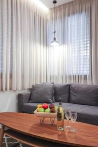 特拉维夫Cozy Apartment in the Heart of Tel Aviv Sea N' Rent的客厅配有一张桌子,放着一碗水果和酒杯