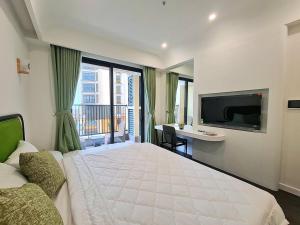 富国Căn Hộ Studio cho 3 người的卧室配有一张白色大床和电视。