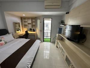 雅加达Apartment Taman Sari - Travelnesian Home的一间卧室配有一张床和一台平面电视