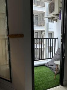 雅加达Apartment Taman Sari - Travelnesian Home的客房设有带绿色地毯的阳台。