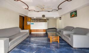 艾哈迈达巴德Treebo Trend Shree Krishna Palace的带沙发和咖啡桌的等候室