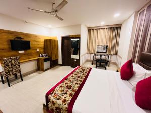 新德里Ashoka International Hotel - Karol Bagh New Delhi的酒店客房,配有床和电视