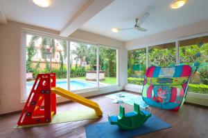莫尔穆冈Veeraas Calangute - 2BHK Apartment with Pool的儿童房设有秋千和游乐场
