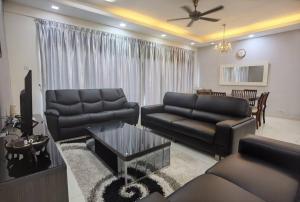 普崇Setiawalk Puchong 5 Bedrooms 14PAX 5 Mins TO LRT的客厅配有沙发和桌子