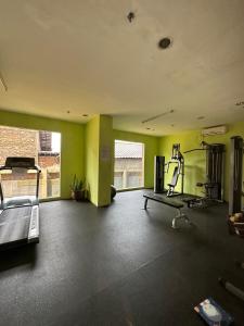 雅加达Apartment Taman Sari - Travelnesian Home的一个带绿色墙壁和跑步机的健身房