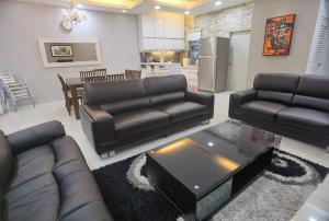 普崇Setiawalk Puchong 5 Bedrooms 14PAX 5 Mins TO LRT的客厅配有黑色真皮沙发和桌子