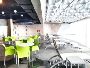 云顶高原TopGenting BambooColdSuite4Pax @GrdIonDelmn的餐厅设有白色的桌子和绿色的椅子