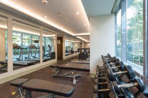 马尼拉Belmont Hotel Manila的健身房设有一排健身器材和窗户