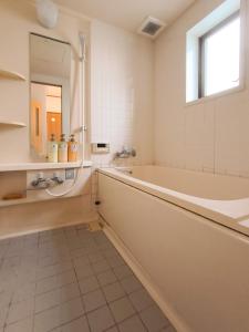 东京Sasatsuka Fleur Tachibana Hotel Apartment的带浴缸、水槽和镜子的浴室