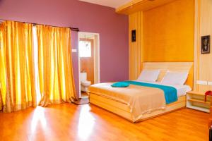 埃尔加德Hotel JK Grand的一间卧室配有床和黄色窗帘