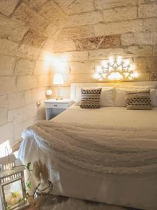莱切Palazzo Emy的一间卧室设有一张带石墙的大床