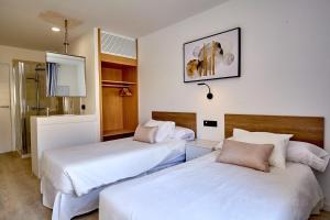 美洲海滩ALEGRIA Barranco的配有白色床单的客房内的两张床
