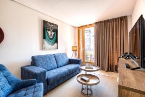 坎布里尔斯CAMBRILS Chic! Apartments by ALEGRIA的客厅配有蓝色的沙发和电视