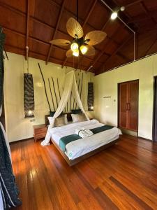 西必洛西必洛森林边缘度假村的一间卧室配有一张带吊扇的床