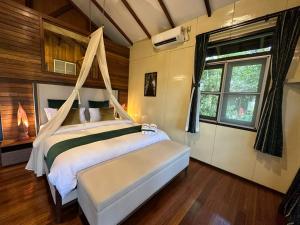 西必洛西必洛森林边缘度假村的一间卧室设有天蓬床和窗户。