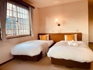 富士河口湖SAMURISE NORTH的带窗户的客房内的两张床