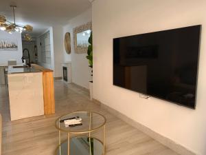 阿尔梅利马Apartamento Center Playa Almerimar的客厅配有壁挂式大屏幕平面电视