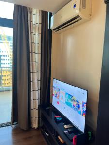 宿务Appleone Ayala Condo with Balcony的窗户客房内的平面电视