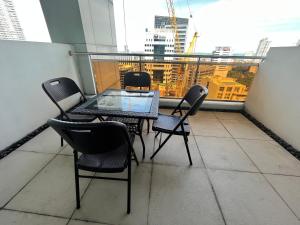 宿务Appleone Ayala Condo with Balcony的美景阳台配有桌椅