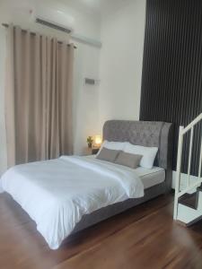 Kota BharuMembunga Village的卧室配有一张带白色床单和枕头的大床。