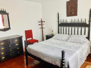 São SebastiãoAlfazema的一间卧室配有一张床、一把椅子和一个梳妆台