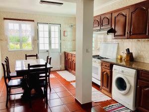 São SebastiãoAlfazema的厨房配有桌子和洗衣机。