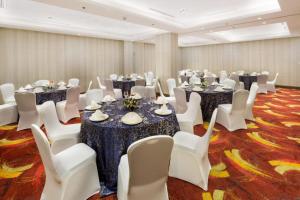 马尼拉Belmont Hotel Manila的一间会议室,配有桌子和白色椅子