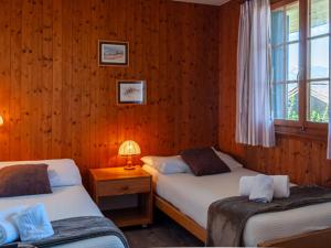 南达Chalet Mustela by Interhome的木墙客房的两张床