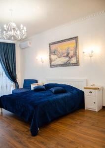 鲍里斯皮尔RELAX COMPLEX HOTEL的一间卧室配有蓝色的床和吊灯。