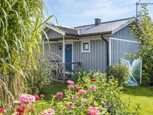 BromöllaHoliday Home Täppan - SKO184 by Interhome的一座带蓝色门和一些花的房屋